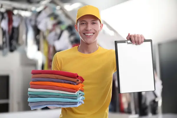 Mutlu Kurye Katlanmış Giysiler Kuru Temizleme Panosu Taşıyor — Stok fotoğraf