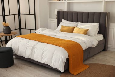 Şık bir yatak odasında, yatakta parlak ekose. İç tasarım