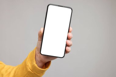 Gri arka planda akıllı telefon gösteren bir adam, yakın plan. Tasarım için model
