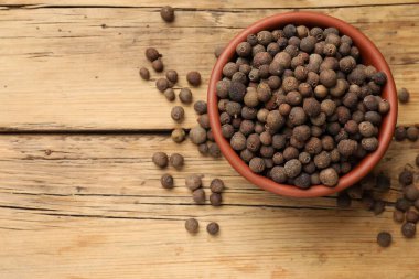 Ahşap masadaki kasede tüm baharatlı biber taneleri, üst manzara. Metin için boşluk