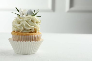 Beyaz masada vanilya kremalı Paskalya keki, mesaj için yer var.