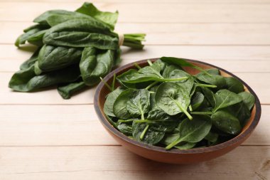 Hafif ahşap masada taze ıspanak yaprakları, yakın plan.