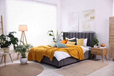 Parlak ekose ve renkli yastıklar şık bir yatak odasında. İç tasarım