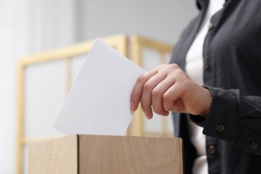 Kadın oyunu puslu arka planda sandığa koyuyor, yakın plan.