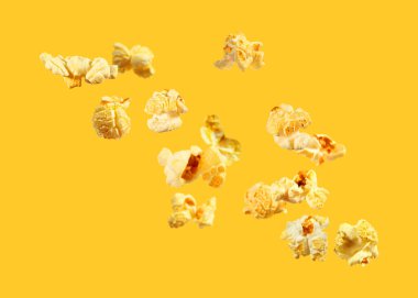 Turuncu arka planda uçan lezzetli patlamış mısır.