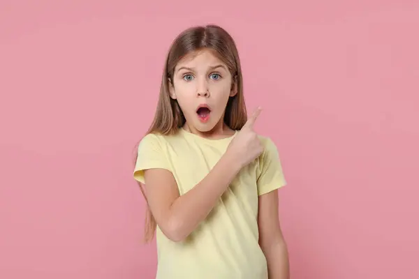 Překvapená Dívka Ukazuje Něco Růžovém Pozadí — Stock fotografie