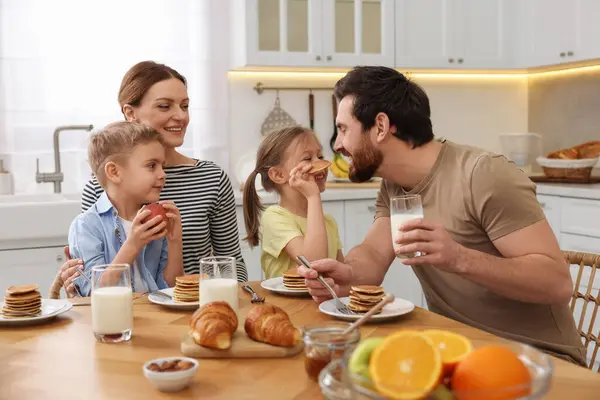 キッチンのテーブルで朝食中に楽しんでいる幸せな家族 — ストック写真