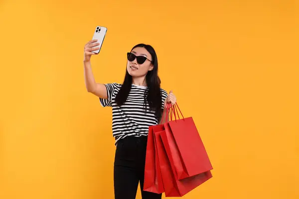 Mujer Sonriente Con Bolsas Compras Tomando Selfie Sobre Fondo Amarillo —  Fotos de Stock