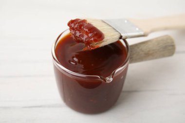 Salamura ve terbiye fırçası beyaz masada, yakın plan.