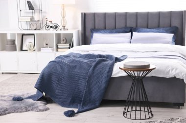 Şık bir yatak odasında, yatakta parlak ekose. İç tasarım