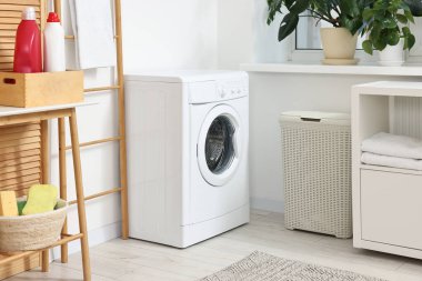 Çamaşır makinesi ve mobilyalarla iç çamaşır odası.