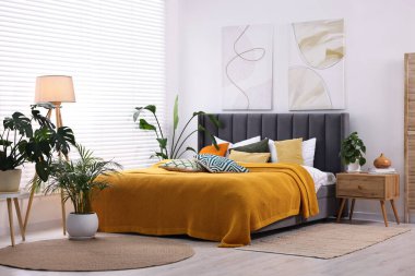 Parlak ekose ve renkli yastıklar şık bir yatak odasında. İç tasarım