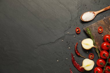 Yemek pişirme konsepti. Tahta kesme tahtası ve siyah masa üzerinde farklı ürünler. Metin için boşluk