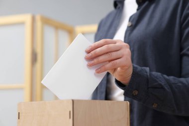 Kadın oyunu puslu arka planda sandığa koyuyor, yakın plan.