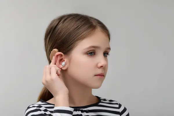 Malá Dívka Naslouchátkem Šedém Pozadí — Stock fotografie