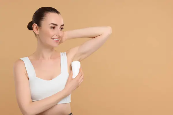 Piękna Kobieta Stosująca Dezodorant Beżowym Tle Miejsce Tekst — Zdjęcie stockowe