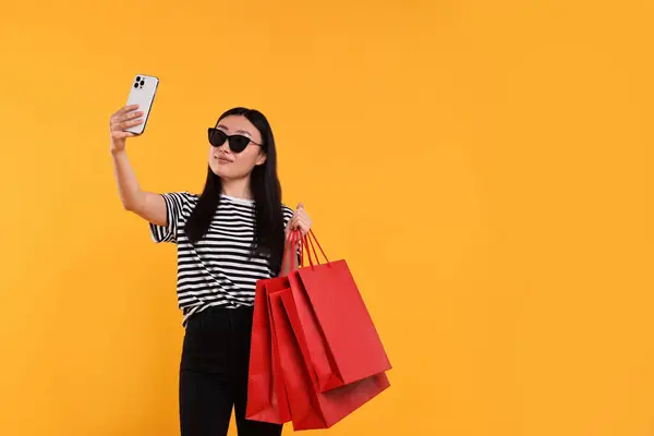 Hermosa Mujer Con Bolsas Compras Tomando Selfie Sobre Fondo Amarillo —  Fotos de Stock