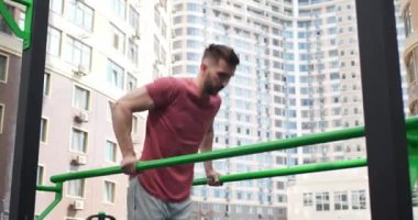 Atletik adam açık hava spor salonunda dalış yapıyor, düşük açılı görüş. Kamera hareket ediyor