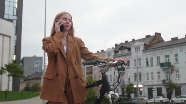 Młoda Kobieta Rowerem Rozmawia Przez Telefon Komórkowy Zewnątrz — Wideo stockowe