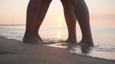 Çiftler gün batımında deniz sahillerinde birlikte vakit geçiriyorlar. Yakın çekim.