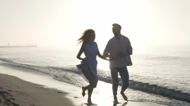 Ευτυχισμένο Ζευγάρι Τρέχει Στην Παραλία Ηλιοβασίλεμα Αργή Κίνηση Παρακολούθηση Κάμερας — Αρχείο Βίντεο
