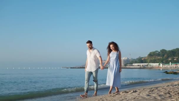 美丽的夫妇在日落时在海滩上散步 视角低 相机跟踪 低运动效果 — 图库视频影像