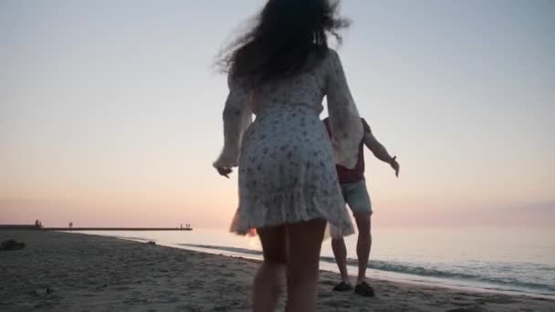 美しいカップルは日没 低い角度のビューで海のビーチで抱擁しています スローモーション効果 — ストック動画