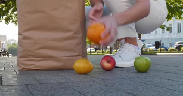Junge Frau Sammelt Umgefallenes Obst Papiertüte Auf Der Straße Nahaufnahme — Stockvideo