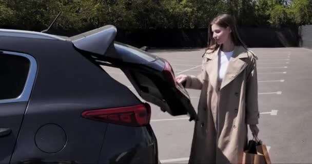 Молода Жінка Кладе Паперові Сумки Багажник Автомобіля Відкритому Повітрі — стокове відео