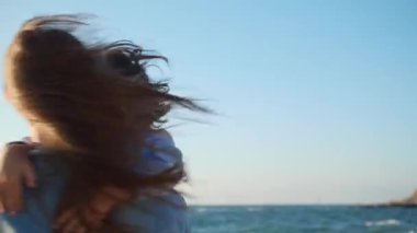 Genç anne ve oğlu deniz kenarında sarılıyor ve dönüyorlar.