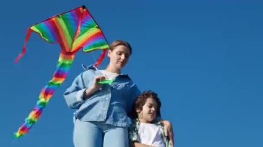 Parlak uçurtmalı anne ve oğlu açık havada, alçak açılı.