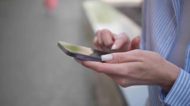 Dışarıda cep telefonu kullanan genç bir kadın, yakın plan. Yavaş çekim etkisi