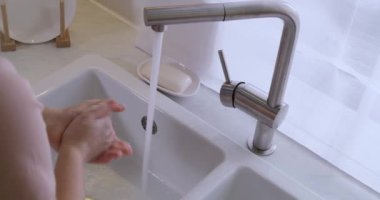 Mutfakta ellerini yıkayan kadın, yakın plan.