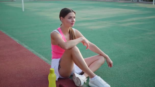 Schöne Frau Stylischer Sportbekleidung Sitzt Tennisplatz Kamera Bewegt Sich Sie — Stockvideo