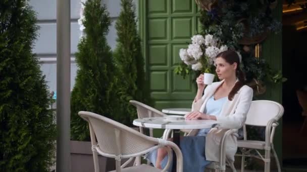 美丽的年轻女子在户外咖啡馆喝咖啡 — 图库视频影像