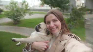 Güzel köpeğiyle çekici bir kadın. Sokakta selfie çekiyor. Akıllı telefon kamerasından görüntü alıyor.