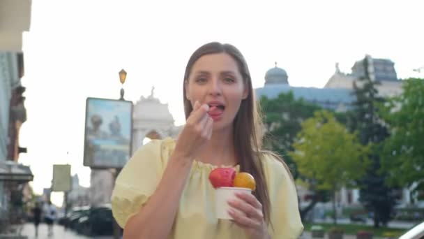 Şehirde Yürürken Dondurma Yiyen Güzel Bir Genç Kadın Kamera Geri — Stok video