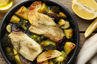 Tahta masada sebzeli, limonlu ve baharatlı enfes fırınlanmış morina balıkları.