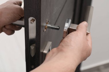 Tamirci kapıyı tamir ediyor. Kapı kolu içeride. Yakın çekim.