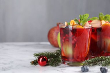 Beyaz mermer masada, bardaklarda, malzemelerde ve Noel dekorunda Aromatik Sangria içeceği, metin için yer
