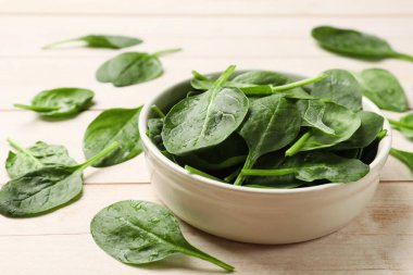 Hafif ahşap masada taze ıspanak yaprakları, yakın plan.