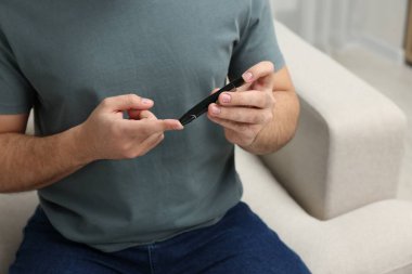Diyabet testi. Kan şekeri seviyesini evde tükenmez kalemle ölçen bir adam var.