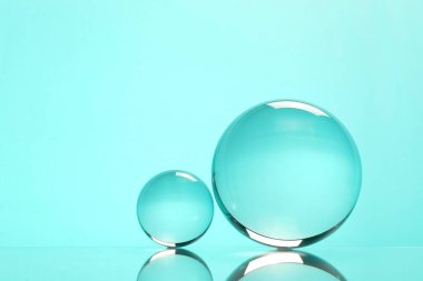 Aynanın yüzeyindeki şeffaf cam küreler turkuaz arka planda. Metin için boşluk