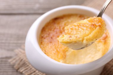 Sofrada kaşıkla leziz bir creme brulee alıp, yakın plan.
