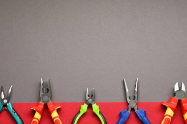 Renkli arka planda farklı pense, düz yatak. Metin için boşluk