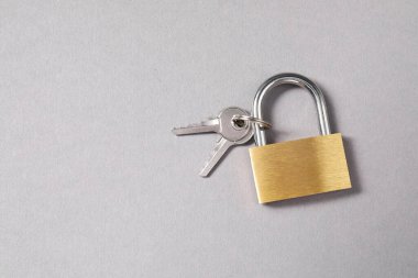 Gri arka planda, üst manzaralı çelik asma kilit. Metin için boşluk