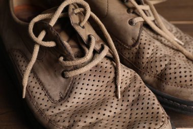 Yoksulluk. Tahta masadaki eski ayakkabılar, yakın plan.