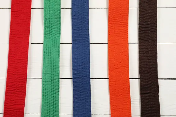 Cinturones Karate Colores Sobre Fondo Madera Planas — Foto de Stock