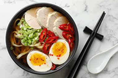 Lezzetli ramen kasede ve kaşıkla beyaz mermer masada, düz yerde. Erişte çorbası.