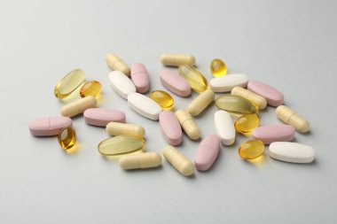 Açık gri arka planda farklı vitamin hapları. Sağlık takviyesi